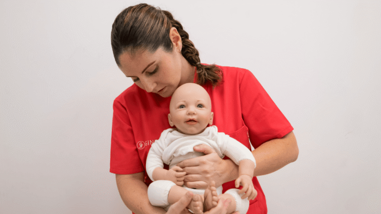 Fisioterapeuta pediátrica Ana García explicando ejercicios con un muñeco de bebé en Ginelux