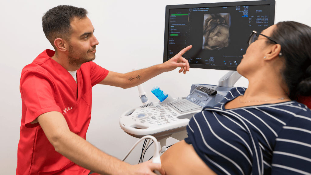 Акушер в Лас-Пальмасе проводит УЗИ при беременности и наблюдает за изображением ребенка вместе с пациенткой.