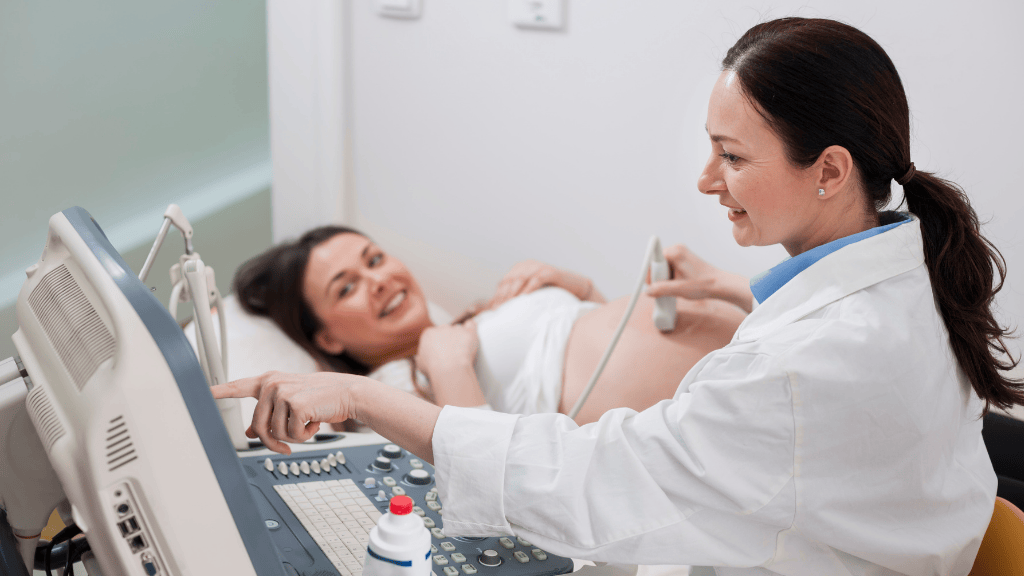 Gynäkologe bei der Ultraschalluntersuchung einer schwangeren Frau während einer Schwangerschaftsuntersuchung